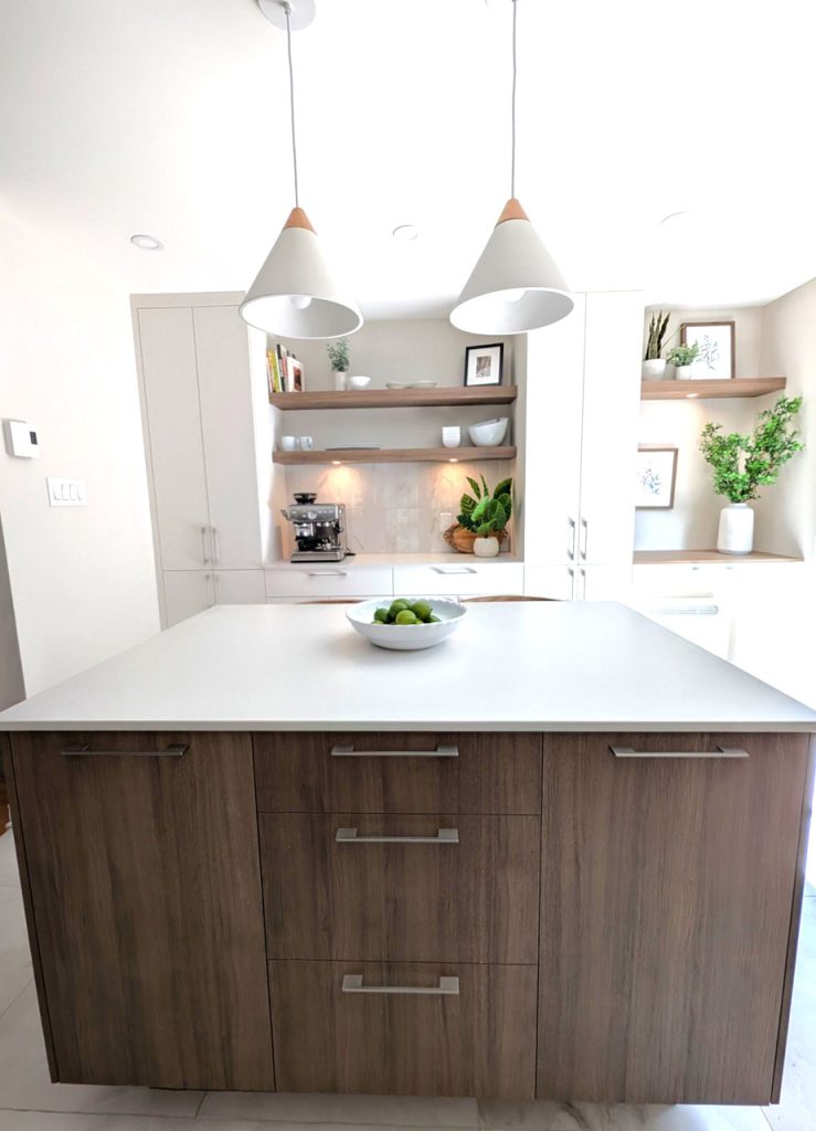 Elegant modern kitchen featuring a wood island, pendant lighting, and refined styling from Lucie Pitt’s Rosemont Serenity interior design project.