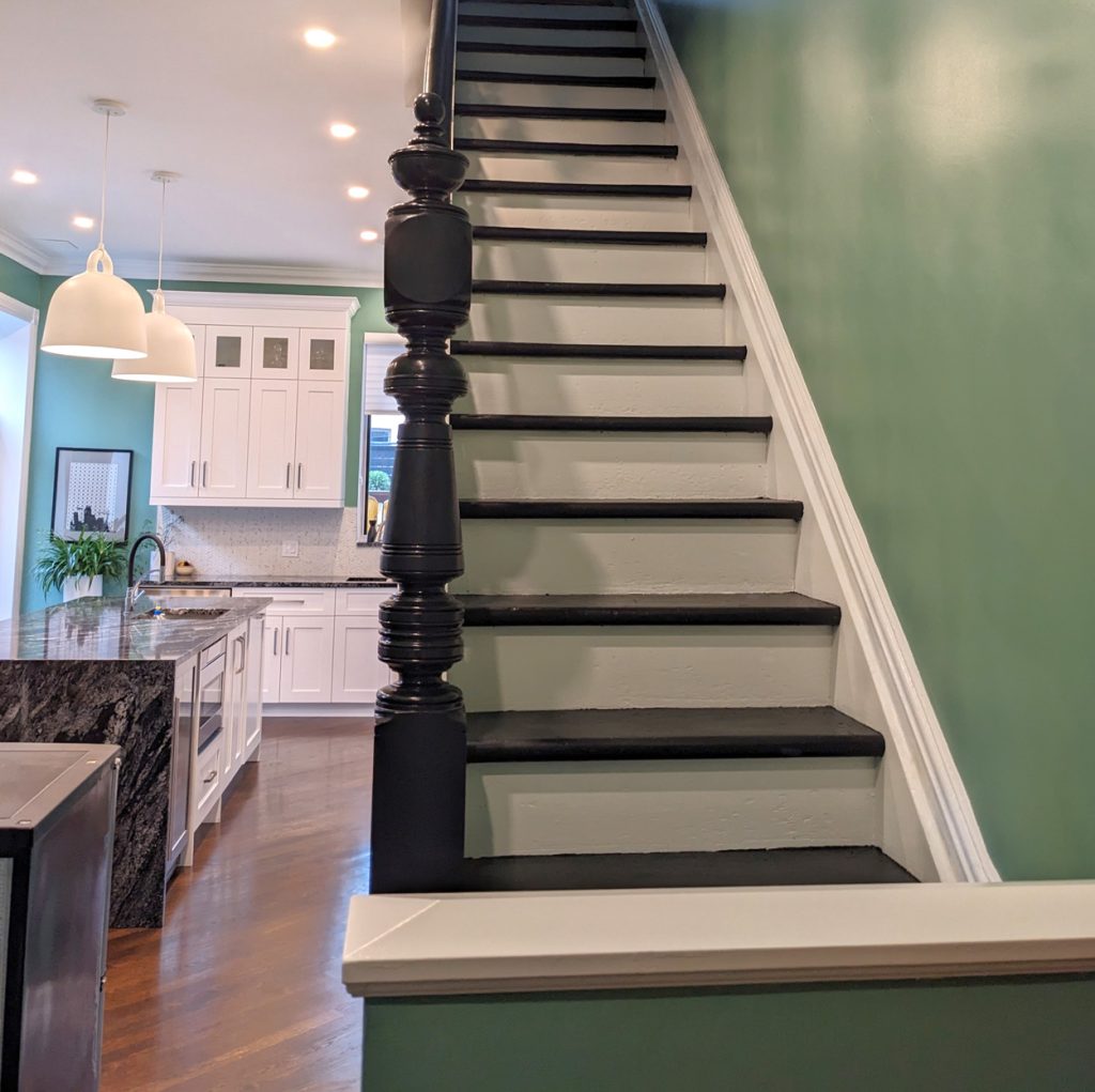 Architectural transition from the staircase into a bright, timeless Westmount kitchen with refined craftsmanship.