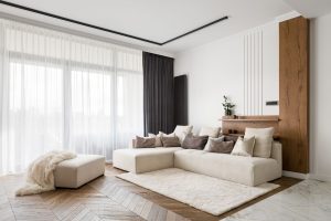 Elegant and comfortable designed living room with big corner sofa, wooden floor and big windows