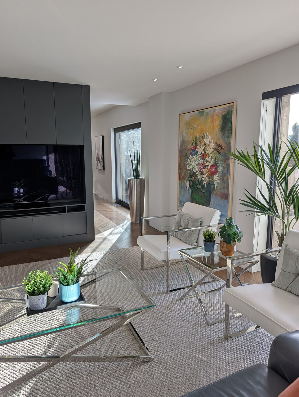 Luxury modern living room with glass coffee tables, custom built-in media wall, and elegant contemporary décor by Lucie Pitt.