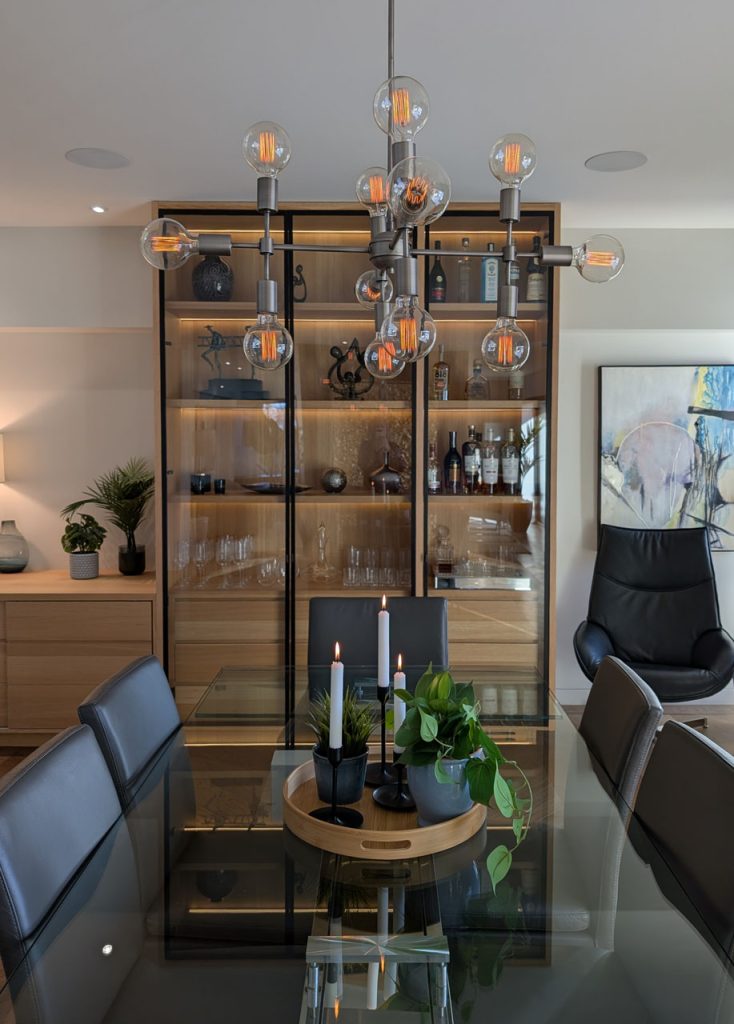 Luxurious dining room featuring sculptural modern lighting, chevron flooring, and curated décor — Habitat 67 refinement by Lucie Pitt.