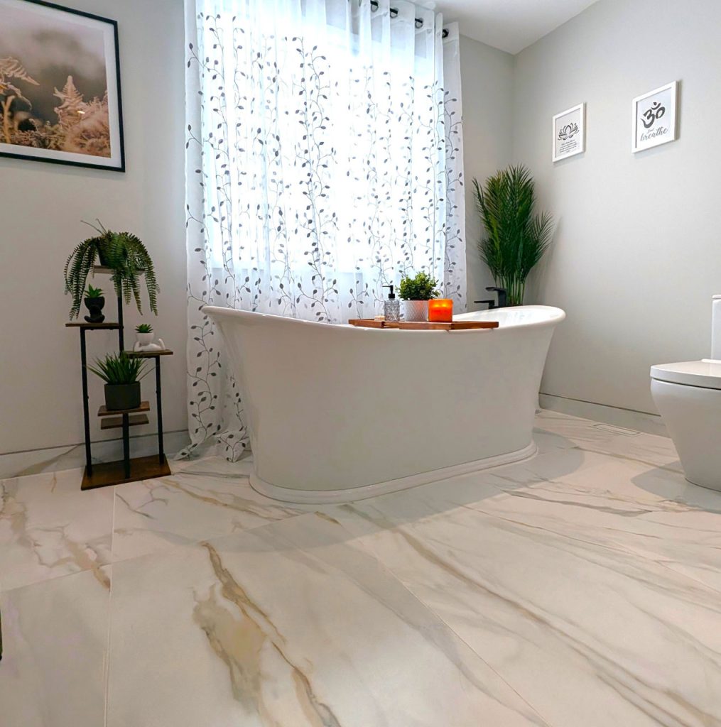 Luxury freestanding bathtub with marble-look porcelain floors, botanical accents, and relaxing spa-inspired ambiance — part of the Laval Harmony project.